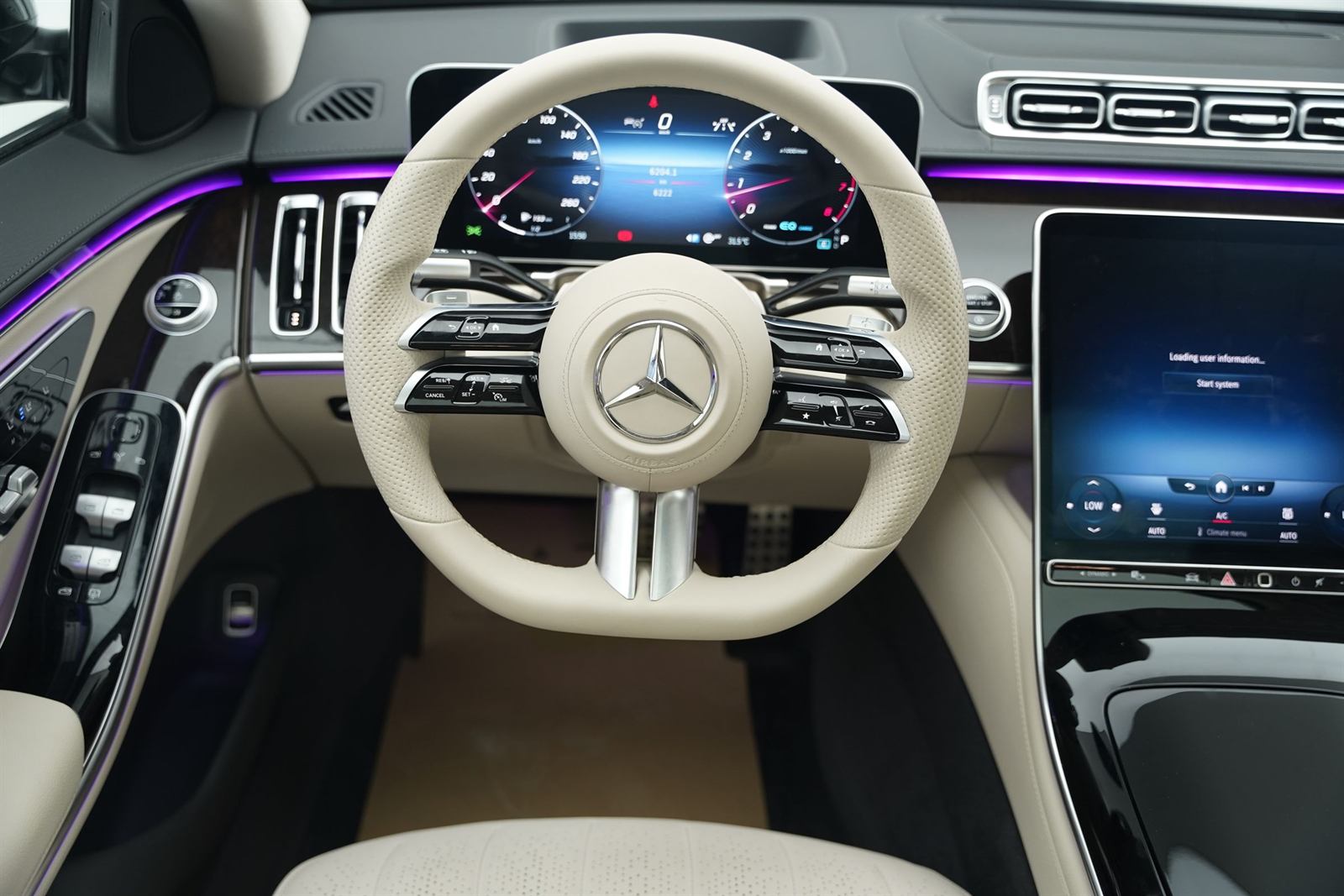 The dashboard of a large sedan, left-hand drive, light leather